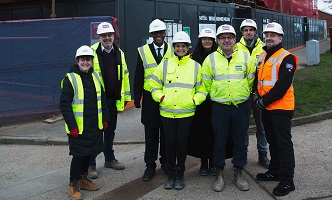 Bim Afolami MP, settle development team and partners from Jarvis Contracting standing in front of John Barker Place development site