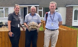 People out on the Summer big door Knock with a residents who is holding his pet. 