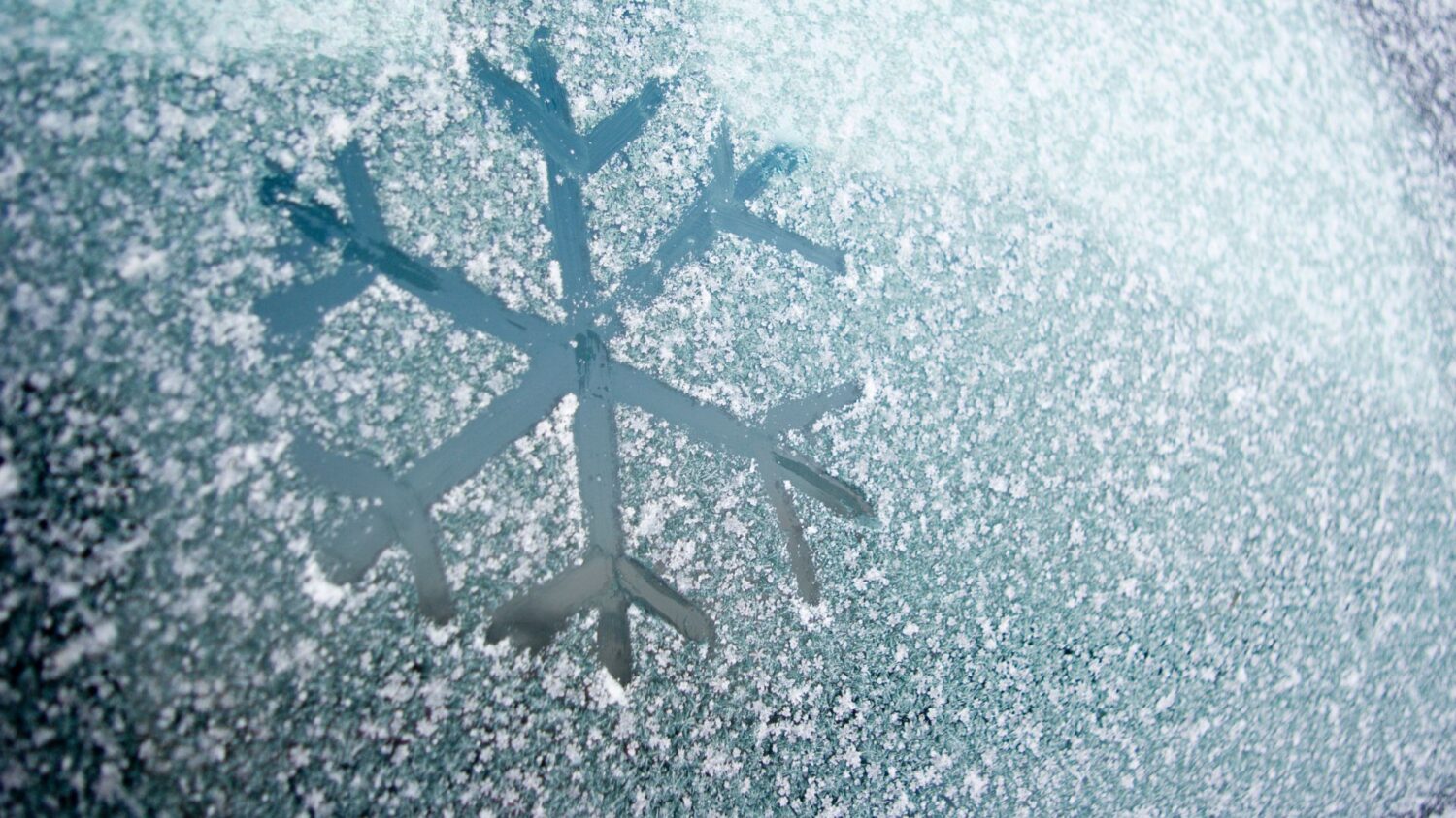 Snowflake drawn in ice on a window.