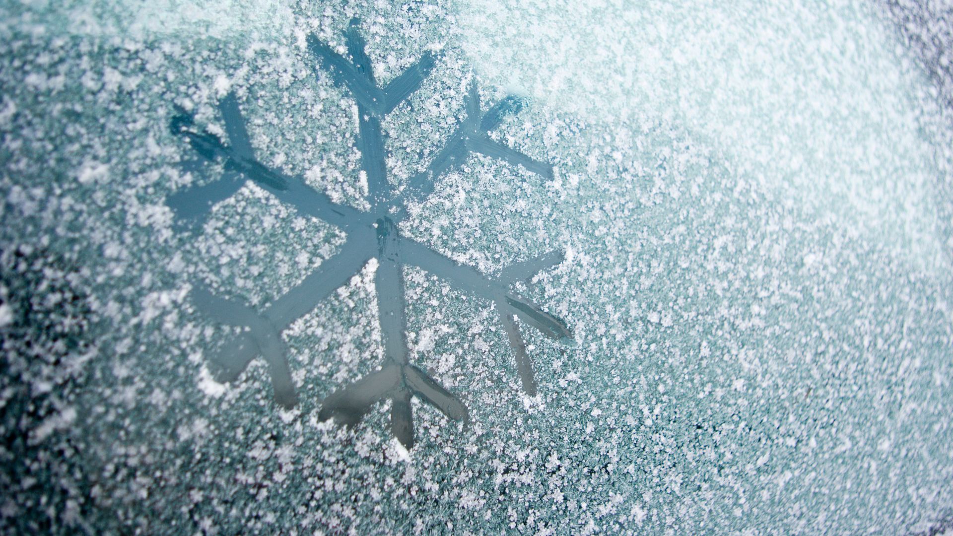 Snowflake drawn in ice on a window.