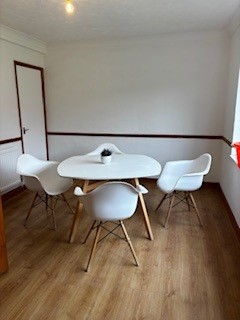 A redecorated meeting room with light, neutral walls and a table and chairs.